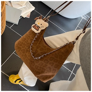 Close-up of leopard print tote bag with metallic chain and a plush character pendant
