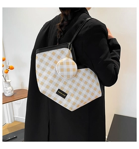 Detail of checkered tote bag with matching round coin purse on a black suit model