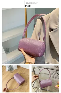 Vue détaillée du sac cylindrique rose pailleté avec doubles bandoulières en cuir et métal
