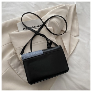 Detail of minimalist rectangular crossbody bag featuring grey-blue and black patchwork
