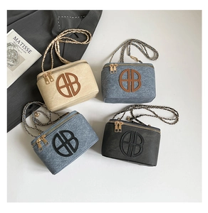 Detail view of box-shaped crossbody bags featuring embossed AB logo and dual zipper design