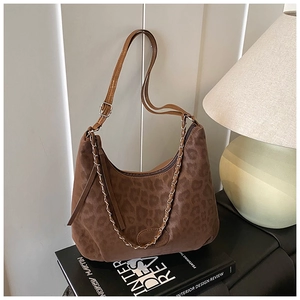 Close-up of leopard print hobo bag with chain strap detail on minimalist books