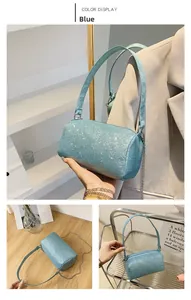 Détail du sac cylindrique à paillettes bleu clair avec paillettes argentées et chaîne