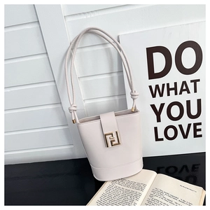 Detail of off-white bucket bag featuring gold double F lock and knotted handles
