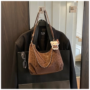 Close-up of brown leopard print suede hobo bag with silver chain and cute cat charm