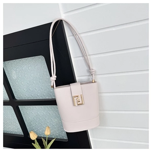 Detail of minimalist cream bucket bag featuring a gold FF magnetic clasp and rope strap