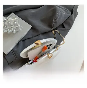Interior view of white acrylic oval handbag showing capacity for phone and lipstick