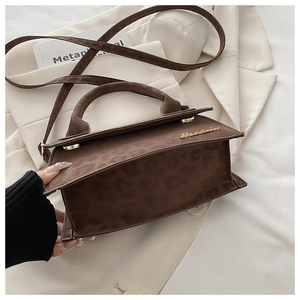 Détail de la texture léopard marron et du logo doré sur le sac à main de mode