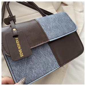 Detailed view of two-tone contrast paneling on stylish rectangular crossbody bag