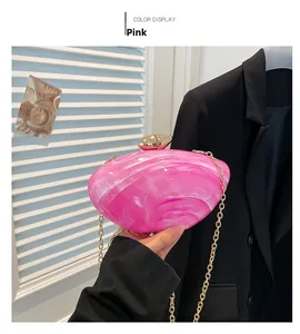 Detail of pink marble resin clutch bag with golden pebble clasp and metal chain strap