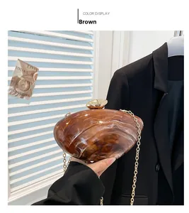 Detail of brown marble acrylic clutch bag with delicate gold chain strap