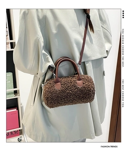 Détail du sac cylindre en faux mouton marron avec poignées en cuir porté par un mannequin