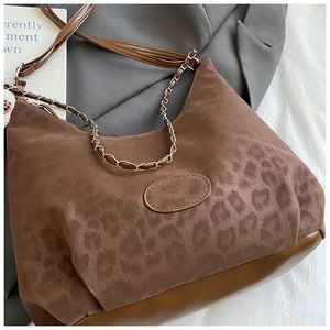 Detail of leopard print suede texture and sleek leather base on a chic shoulder bag