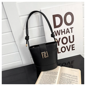 Detail of black faux leather bucket bag with gold square buckle and cord strap