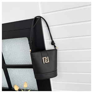 Detail of black leather bucket bag featuring gold-tone interlocking logo and knot hardware