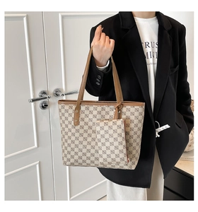 Detail of the vintage plaid tote set and small pouch shown on a model's shoulder