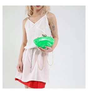 Detail of emerald green marble acrylic clutch bag with golden pebble clasp and chain