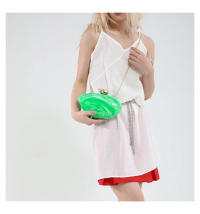 Detail of green acrylic handbag with marble texture and golden sphere clasp
