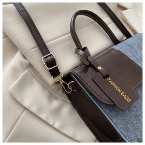 Detail of the brown and blue textured leather crossbody bag with golden hardware accents