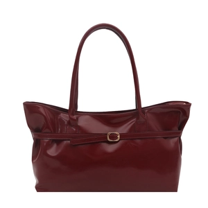 Minimalist burgundy glossy tote bag with dual handles and gold buckle accent in center