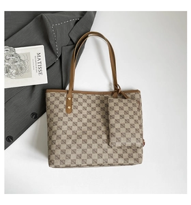 Macro shot of geometric tote bag with matching pouch and brown leather handles