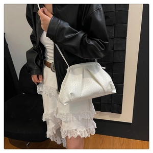 Detail of white woven texture and pleated cloud design on this versatile crossbody bag