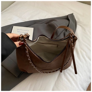 Top view of open brown suede shoulder bag with silver chain and internal zipper pocket