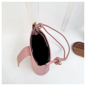 Overhead view of pink mini bucket bag showing black lining and gold ball hardware detail