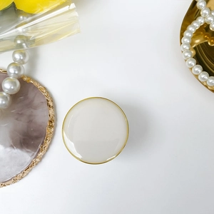 Foldable circular phone socket in cream white with a sophisticated gold metal rim finish