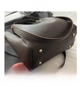 Dettaglio del fondo della borsa tote marrone vintage con rivetti protettivi in metallo oro
