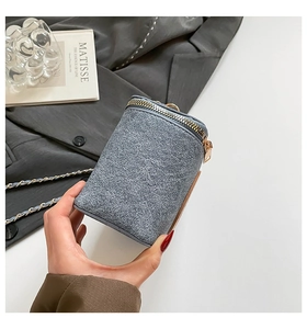 Detailed shot of grey-blue tweed mini bag with gold chain and zipper closure detail