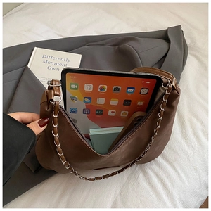 Detail view of brown PU leather bag showing spacious interior for tablets and chain strap