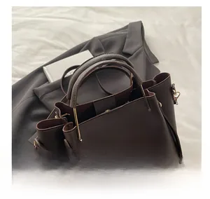 Dettaglio della borsa in pelle marrone scuro con elegante manico in metallo dorato