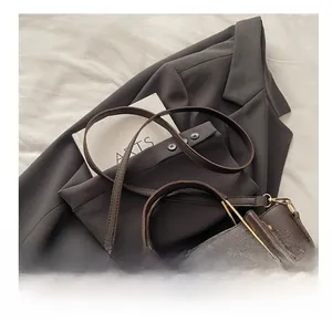 Dettaglio della trama in pelle martellata marrone scuro di una borsa a secchiello