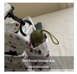 Detail view of large tote bag side pocket holding a compact green folding umbrella