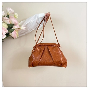 Detailed view of brown woven texture PU leather shoulder bag with handle and knots