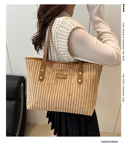 Dettaglio della trama in velluto a coste e dell'etichetta in pelle della borsa beige