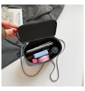 Detail view of denim box bag interior showing phone and makeup storage space