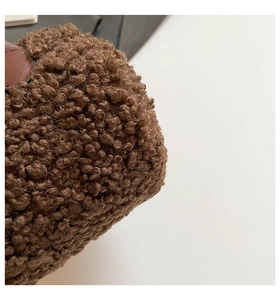 Vue macro de la texture en fausse fourrure brune et détails en cuir du sac polochon