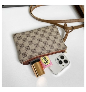 Detail of monogram canvas pouch with gold zipper showing interior capacity for essentials