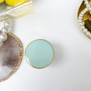 Foldable circular phone socket in mint green gloss finish with a golden metal frame