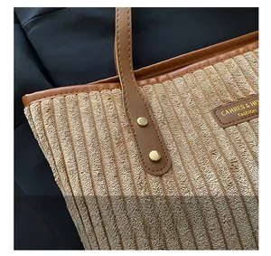 Dettaglio macro della borsa in velluto a coste beige con cinturino in pelle marrone