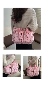 Detail of pink cherry print tote bag with functional multiple zippers and crossbody strap