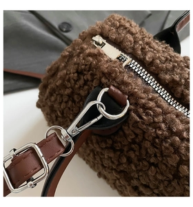 Détail du sac bandoulière en peluche marron avec fermeture éclair et sangle en similicuir