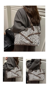 Detail showing the dense leopard print fabric and brown leather handle of the tote bag