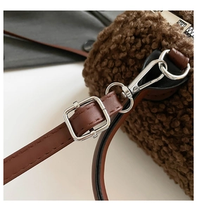 Détail du sac en polaire pelucheuse marron montrant les boucles en métal et la sangle