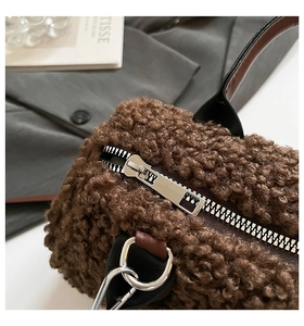 Détail de la texture pelucheuse marron et de la fermeture éclair argentée du sac à main
