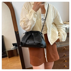 Detail of black woven leather cloud bag showing fine Intrecciato texture and crossbody strap