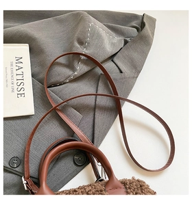 Détail du sac polochon en peluche marron avec bandoulière et décor de livre de Matisse