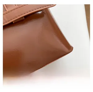 Gros plan du sac en cuir marron montrant la texture premium et les coutures nettes